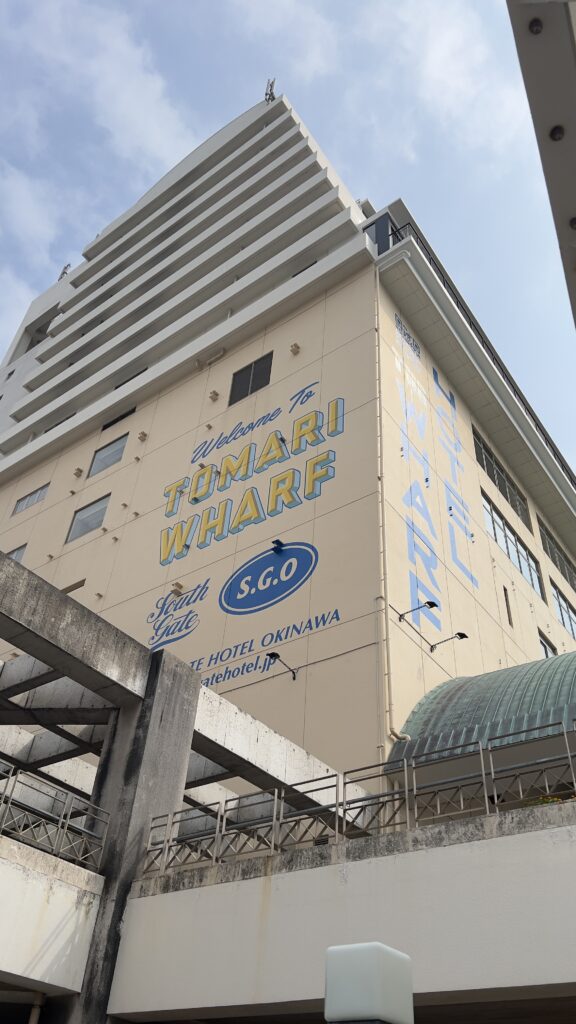 青空の下にそびえ立つサウスゲートホテル沖縄の建物全体像