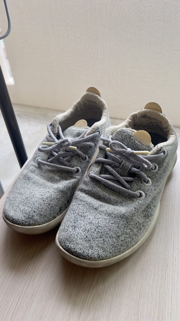窓際の自然光に照らされた、愛用感のあるグレーのAllbirds Wool Runner。ウール素材の柔らかな質感が特徴。