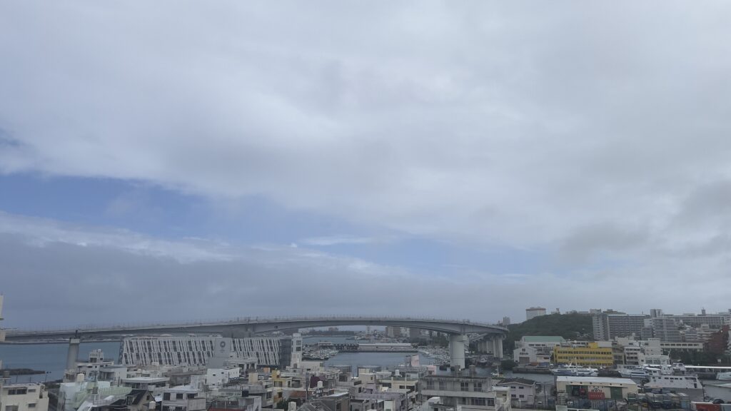 台風7号が通過した後の沖縄県那覇市の泊大橋と那覇港周辺の街並み。雲の間から青空が見える天気