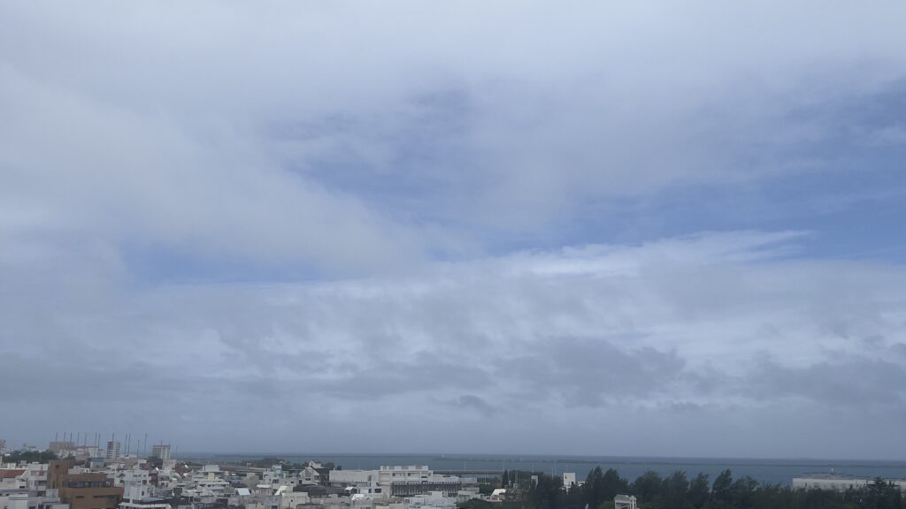台風7号通過後の沖縄県那覇市から望む慶良間諸島方面の空。厚い雲の切れ間から青空が見えている様子