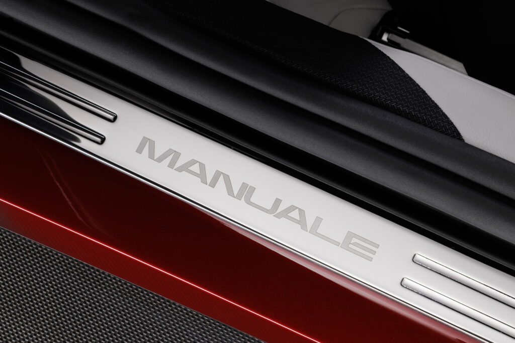 フェラーリ 12チリンドリ マヌアーレの車内に配された、アルミニウム製の質感高い「MANUALE」ロゴ刻印プレートのクローズアップ